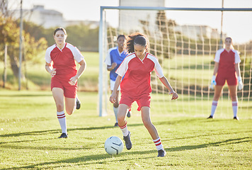 Image showing Female football, sports and girls team playing match on field while kicking, tackling and running with a ball. Energy, fast and skilled soccer players in a competitive game against opponents outdoors