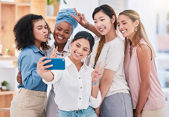 Image showing Fun, diverse and playful team selfie on phone and having fun, goofing around or making peace sign gesture. Cheerful goofy group of business friends or creative colleagues posing for social media post
