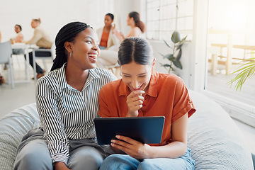 Image showing Laughing, funny and happy creatives browsing digital tablet while relaxing on beanbag in trendy startup office. Colleagues enjoying fun break, watching hilarious video and joke on social media online