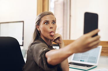 Image showing Phone selfie with a playful business woman having fun, being goofy and joking while working in her office. Young female sticking out her tongue and making a face at work while feeling carefree