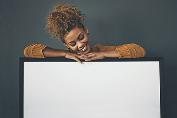 Image showing Woman holding blank poster, copy space board and placard sign to promote, market and advertise opinion or voice on female empowerment. Smiling, young and happy lady endorsing with billboard in studio