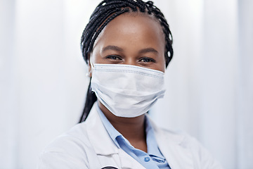 Image showing Doctor wearing hygiene face mask for covid, safety and precaution in the healthcare industry. Portrait and face of confident black medical practitioner and coronavirus frontline worker in a hospital