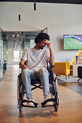 Image showing A sad businessman in a wheelchair occupies a hallway within a modern startup coworking center, embodying inclusivity and determination in the business environment