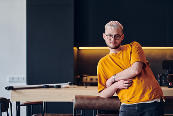 Image showing A man takes a brief rest from work in a modern startup coworking center, using the moment to recharge and relax with technology by his side.