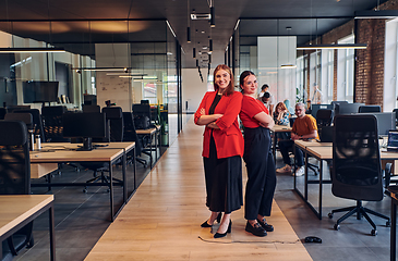 Image showing Group of determined businesswomen confidently pose side by side in a modern startup coworking center, embodying professionalism and empowerment