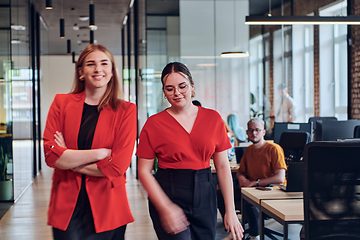 Image showing Group of determined businesswomen confidently pose side by side in a modern startup coworking center, embodying professionalism and empowerment