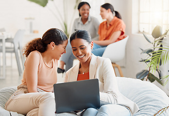 Image showing Group of business women on a laptop sitting, laughing looking at social media during a break. Happy ladies bonding on a couch at work. Excited team of girls celebrating new goal achieved at startup