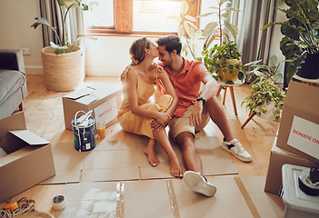 Image showing New home owners moving into a house showing affectionate, taking a break from painting and remodeling the living room interior design. In love and loving house wife kissing husband after decorating