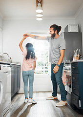 Image showing Father and daughter dancing together, having family fun in the kitchen at home. Carefree, happy and loving parent teaching a little girl how to dance, practicing routine and bonding