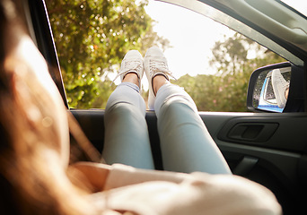 Image showing Relaxed, content and happy woman relax while enjoying the sunny morning in a car. Back view of female with feet out her window taking a break from driving sitting and enjoying the summer sunshine day