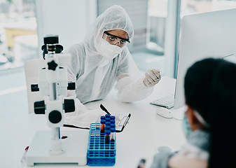 Image showing Covid and disease healthcare worker wearing hazmat suits in a consultation. Doctor writing a medical report about a corona case patient or statistics and writing a form for a safety virus check