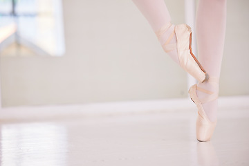 Image showing Ballet feet or legs on the tiptoe dancing or practicing in a dance studio or class with copy space. Closeup of an elegant dancer or ballerina in pointe shoes preparing for a performance