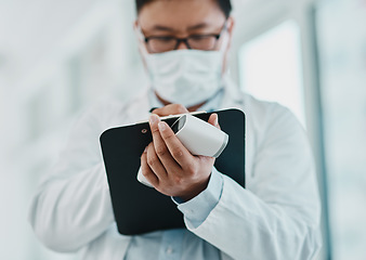 Image showing Covid, pandemic and virus, doctor or medical healthcare worker writing on a clipboard. Scientist wearing a mask to prevent the spread of the sickness and keep a checklist of infected patients