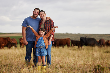Image showing Happy family standing on a farm, cow in background and with a vision for growth in industry portrait. Countryside couple, people or farmer in a field of grass, cattle and free range livestock animals