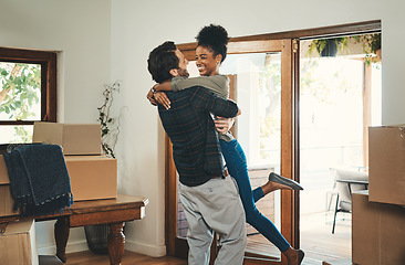 Image showing Homeowner couple celebrating, hugging and cheering in new home as real estate investors, buyers and owners. Fun interracial man and woman looking excited, happy and cheerful while embracing by boxes