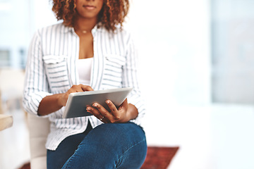 Image showing Female holding a tablet, scrolling the web online and social media at home. Casual woman checking emails and taking a break on the internet. Lady using modern technology to relax inside