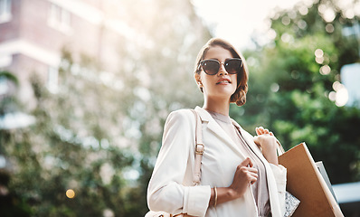 Image showing Elegant woman holding shopping bags after a spending spree, retail therapy and buying clothes in a city. Trendy, stylish and fashionable lady purchasing gifts, presents and classy clothing downtown