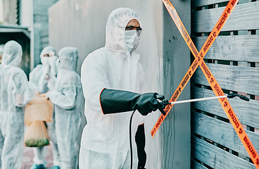 Image showing Hazmat wearing medical and healthcare worker sanitizing and cleaning a quarantine and contamination site. Medical professional stopping the spread of a virus or infection of a building in the city