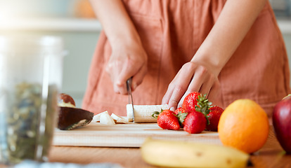 Image showing Healthy woman cutting fruit to make a smoothie with nutrition for an organic diet at home. Closeup of caucasian female hands chopping fresh produce for a health drink in a kitchen.