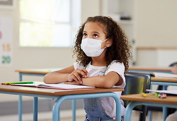 Image showing Child or student in class during covid, wearing a mask for hygiene and protection from corona virus flu. Little kindergarten, preschool or elementary school girl sitting in a classroom ready to learn