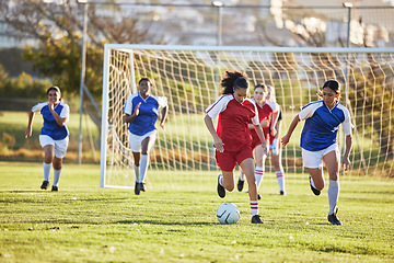 Image showing Sports team, girl soccer and kick ball on field in a tournament. Football, competition and athletic female teen group play game on grass. Fit adolescents compete to win match at school championship.