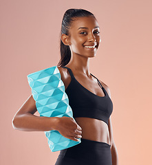 Image showing Foam roller for fit athlete to massage sore muscles after workout, training and exercise against colorful studio background, Portrait of a toned, smiling and active young woman with healthy lifestyle