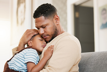 Image showing Sleeping and tired child with caring father holding his sleepy son on a home lounge sofa. Worried dad hugging his young boy resting on a living room family couch indoors feeling stress and worry