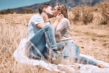 Image showing Kissing, in love and young couple on picnic valentine date outdoors in sunny summer or spring. Intimate, passionate and dating romantic cute boyfriend and girlfriend in relationship together outside.