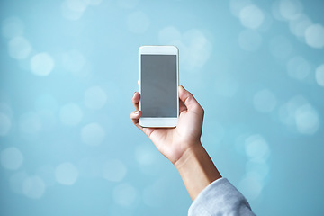 Image showing Female hand, isolated, holds phone with blank screen with copy space ready for your app or online internet search Close up of a businesswoman holding a smartphone against a blurred blue background