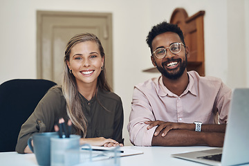 Image showing Happy diverse employees working together on a project sitting in an office table satisfied with the partnership. Portrait of young colleagues with a positive mindset smiling about business growth