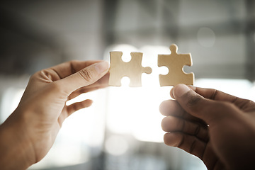 Image showing Teamwork, unity and growth with puzzle pieces in the hands of business people building, growing and working together as a team. Closeup of colleagues showing togetherness and synergy from below