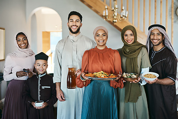 Image showing Smiling, festive muslim family celebrating eid or ramadan party lunch together holding dishes of food at home. Happy, traditional islamic religion group of friends enjoying cultural holiday