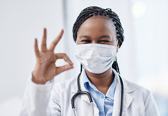 Image showing Doctor gesturing okay hand sign, symbol and emoji to express success and agreement in a good clinic or hospital. Portrait of a smiling medical pathologist looking happy after finding a cure for covid