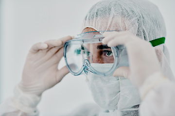 Image showing Covid, pandemic of young man putting on his protective gear for health and safety from the virus. Serious professional infection fighter ready to combat the spread of the disease or illness.