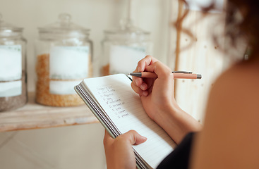 Image showing Budget planning, making shopping list and managing household expenses to save money. Financial accountability at home. Woman making shopping list for groceries on a notebook to plan a meal for dinner