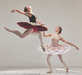 Image showing Ballerina, ballet dancers and performance artists jumping in the air with flexibility, motion and balance in a studio. Energy, energetic and classical performers dancing together for fitness in hall