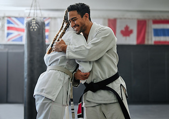 Image showing . Karate trainer giving hug to female student for motivation, coach embracing for support and celebration after winning competition. Teammates and friends training and learning martial arts at a gym.