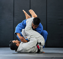 Image showing . Men fighting during karate training at fitness studio, doing fight club workout at gym and learning dojo moves as exercise at sports center. Strong, fit and tough people doing physical activity.