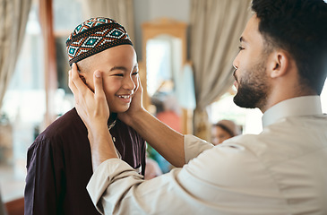 Image showing Affectionate, loving and caring Muslim father and son talking and bonding on Eid holiday. Cute, smiling and happy Islamic child listening to advice from dad while wearing a traditional outfit