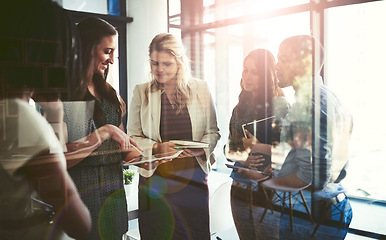 Image showing Businesspeople talking about a innovation project together as a team on a tablet after a collaboration meeting in a modern office. Executive men and women in a group discussion about a smart strategy