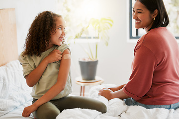 Image showing Girl with covid vaccine shows mother vaccinated arm with plaster as covid19 protection for a kid in a bedroom home. Child after getting an injection bonding with her mom in the bedroom