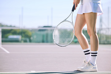 Image showing Legs of a female tennis player practicing or training for a match outdoors on the court on a sunny day. Active, fit and athletic female athlete or sportswoman playing a sport for a club