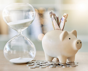 Image showing Money, finance and saving with a piggy bank and hourglass on a tablet or desk with time, cash and coins. Financial investment, retirement or planning for the future with a .budget and growth strategy