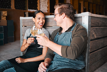 Image showing Successful distillery owners relaxing and celebrating with a glass of wine in the cellar or warehouse. Relaxed winemakers or employees enjoying an alcohol drink together at work