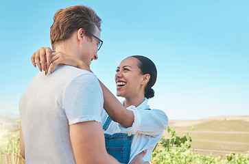 Image showing Laughing, in love and happy interracial couple in hug, embrace or holding each other on wine tasting farm. Fun, playful or loving man and woman standing close and enjoying countryside vineyard estate