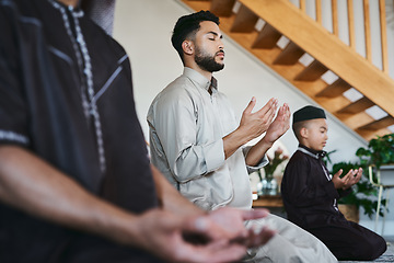 Image showing Muslim family praying together at home with eyes closed during fajr, dhuhr, asr, maghrib or Isha. Practicing religion and cultural tradition to serve or worship the god of their faith and belief