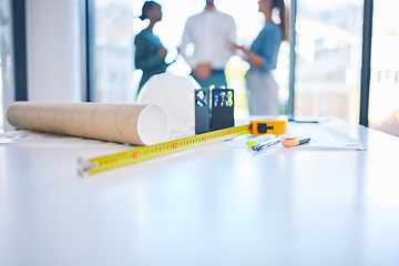 Image showing Architecture, construction and building with plans, blueprints and tape measure on a desk in an architect office. Closeup of engineer or contractor equipment on a table ready for planning and design