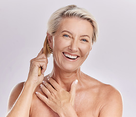 Image showing Grooming, hygiene and hair care for a mature woman brush and style grey hair, smiling and happy. Portrait of a senior female enjoying selfcare and treatment, pamper session against pink background