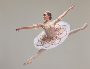 Image showing Jumping ballet dancer or ballerina performer dancing in a beautiful, elegant tutu dress or fashion design costume in studio performance. Talented, professional dance artist jump a in ballon pose