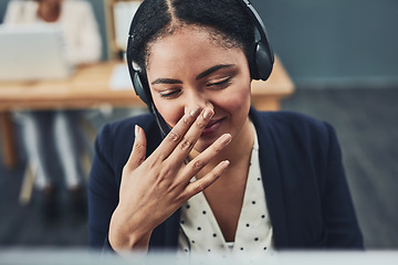 Image showing Young call centre agent covers their mouth to hide their smile. The client makes the employee happy with their positive feedback or joke. Building a professional and friendly relationship online.